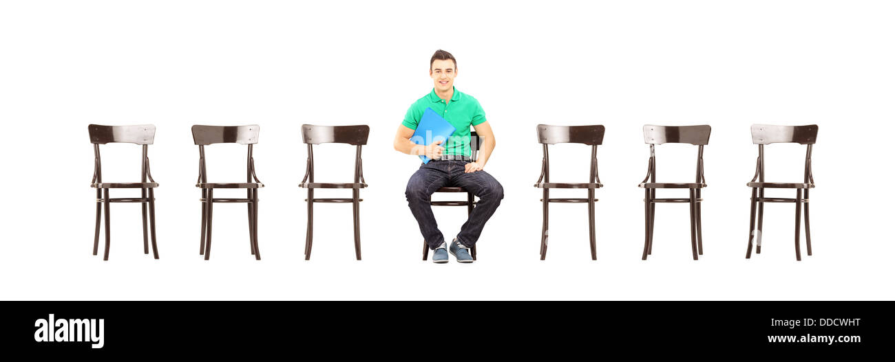 Beau jeune homme assis sur une chaise et en attente d'entrevue d'emploi Banque D'Images