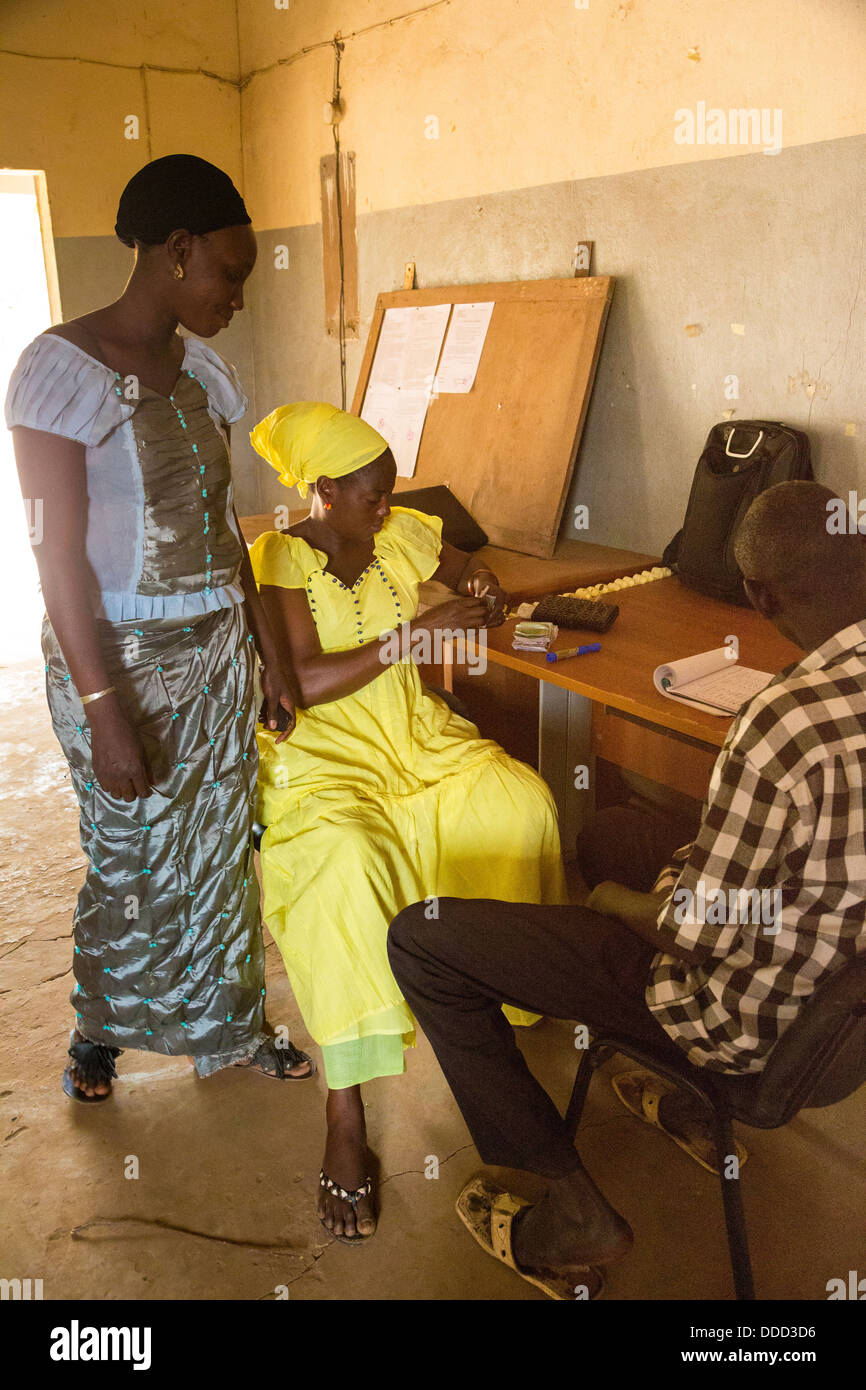 La microfinance. Femme de payer de nouveau son petit prêt. Kaymor, au Sénégal. Un projet Africare. Banque D'Images