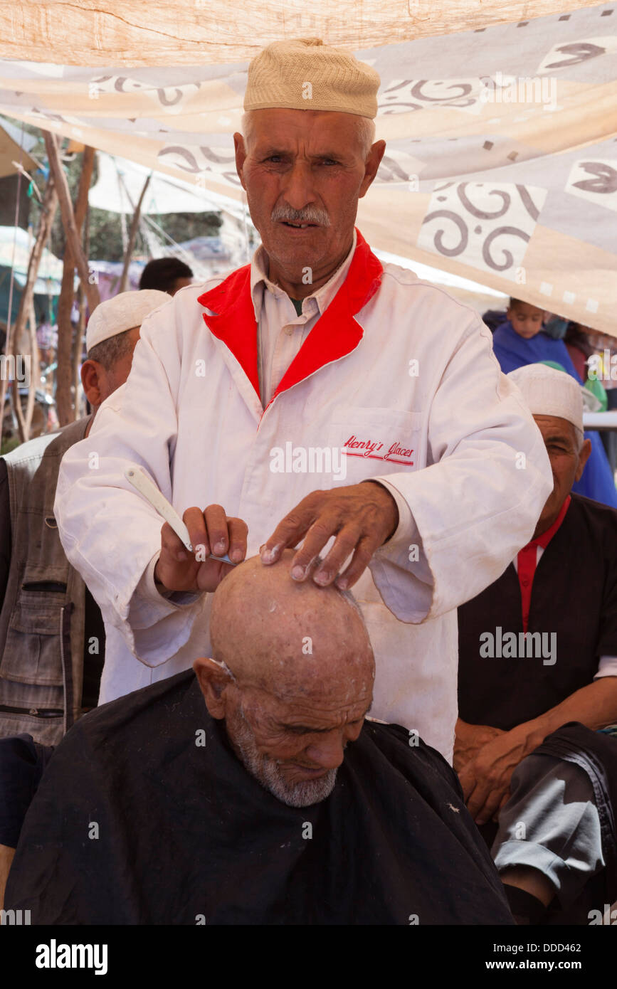 Vieil homme local faisant couper les cheveux à la marché berbère lundi à Tnine Ourika Banque D'Images