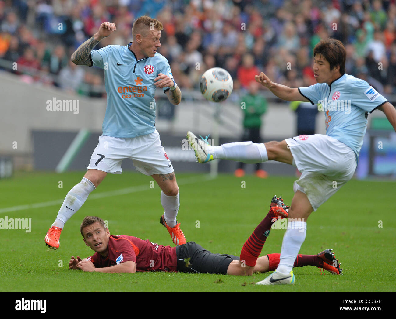 Hanovre, Allemagne. Août 31, 2013. Artur Sobiech du Hanovre (sur le terrain) pour les vies la balle avec Mayence's Edgar Pribum (L) et Park Joo-Ho (R) au cours de la Bundesliga match de foot entre Hanovre 96 vs FSV Mainz 05 à IDH-Arena de Hanovre, Allemagne, 31 août 2013. Photo : CARMEN JASPERSEN (VEUILLEZ NOTER : En raison de directives d'accréditation, le LDF n'autorise la publication et l'utilisation de jusqu'à 15 photos par correspondance sur internet et dans les médias en ligne pendant le match.)/dpa/Alamy Live News Banque D'Images