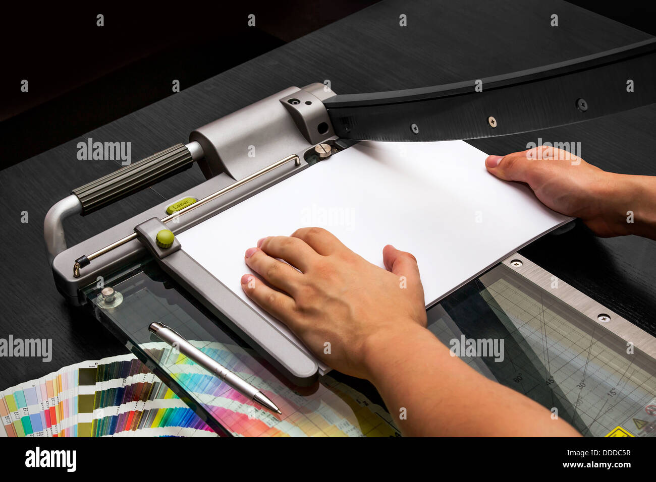 L'homme travaillant sur la guillotine pour le papier Banque D'Images