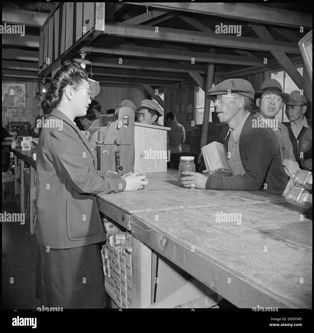 Manzanar Manzanar, Centre de réinstallation, en Californie. Une vieille personne évacuée achète le beurre d'arachide pour une . . . 536927 Banque D'Images