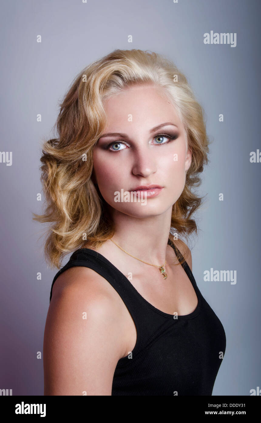 Un modèle de beauté pose farouchement en studio, l'éclairage dramatique avec cheveux inspiré de Marilyn Monroe Banque D'Images