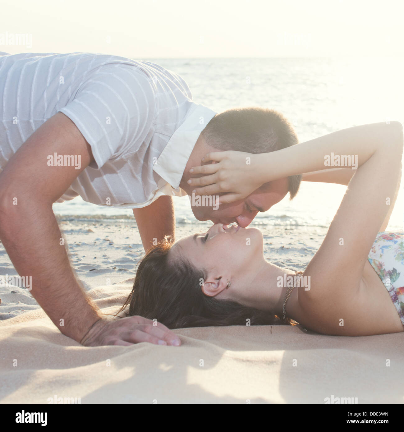 Beautiful couple couché et baiser sur la plage. guy bisous sur top Photo  Stock - Alamy