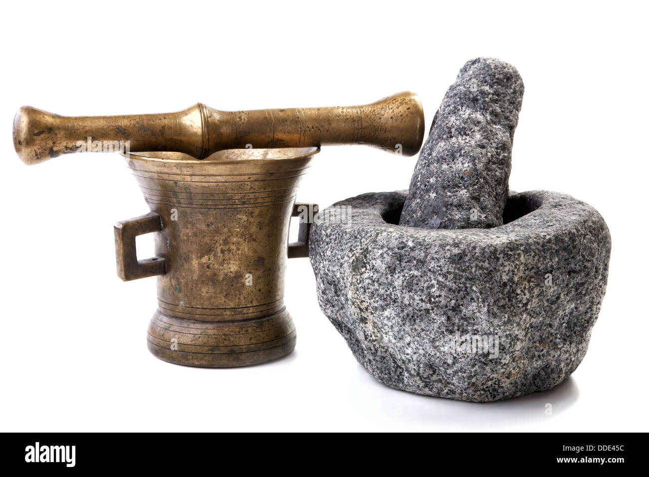 Le Granit et le mortier en laiton avec des pilons sur un fond blanc Banque D'Images