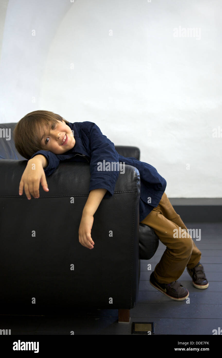 Jeune garçon affalé sur un canapé Photo Stock - Alamy