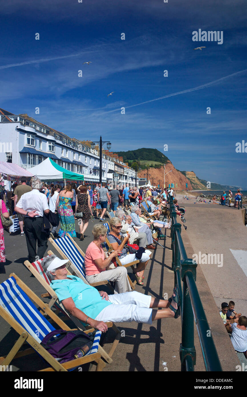 Les vacanciers se détendre sur l'esplanade au cours de Sidmouth Folk Festival, Devon, UK Banque D'Images