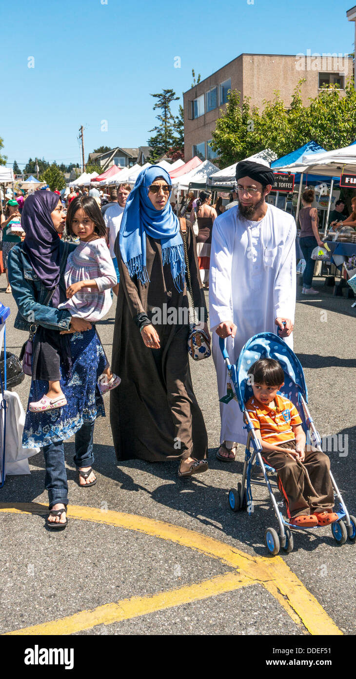 Famille musulmane avec 2 jeunes enfants flâner passé les étals d'artisanat et de l'été samedi Edmonds greenmarket farmers market Banque D'Images