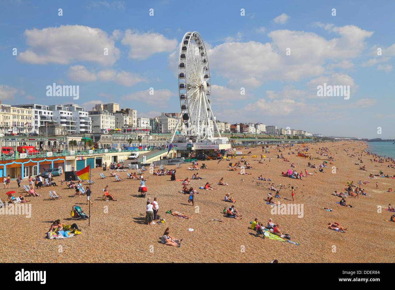 Les vacanciers à bronzer sur la plage de Brighton sous le soleil d'été, East Sussex, UK Banque D'Images