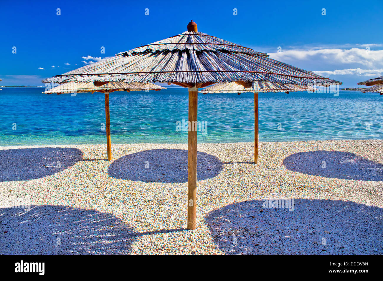 Plage de galets et mer turquoise parapluie, la plage Zrce, île de Pag, Croatie Banque D'Images