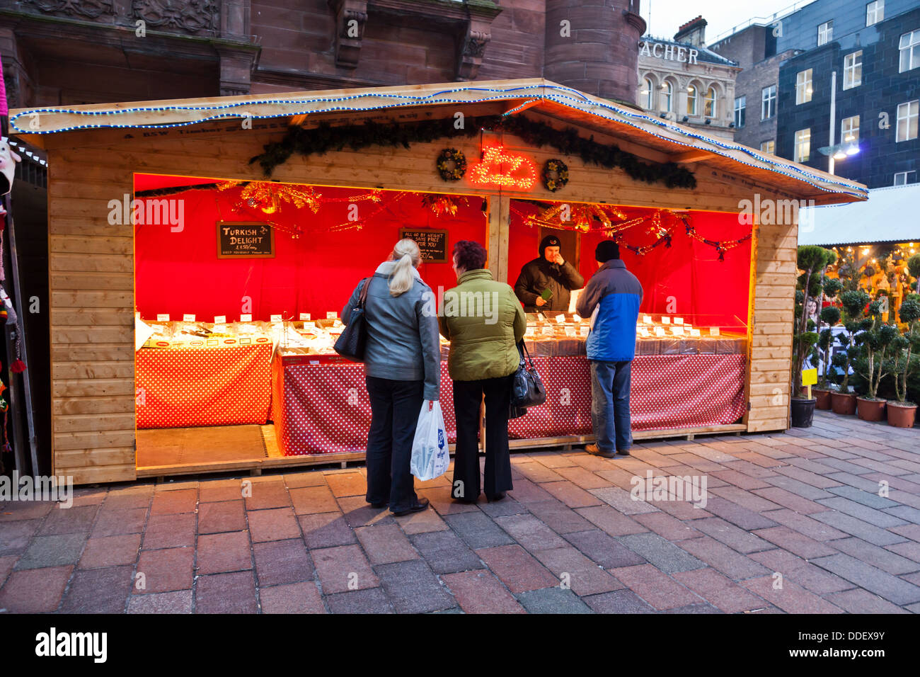 Titulaire de décrochage et clients à un sweet stand au marché de Noël, St Enoch Square, Glasgow Banque D'Images