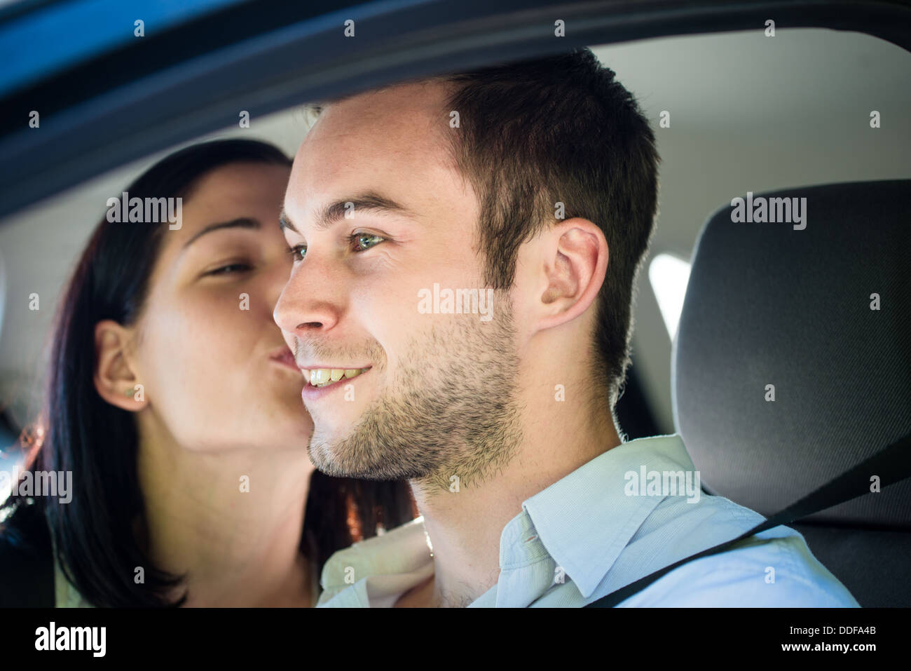 Couple in love - woman kissing man in car en roulant Banque D'Images