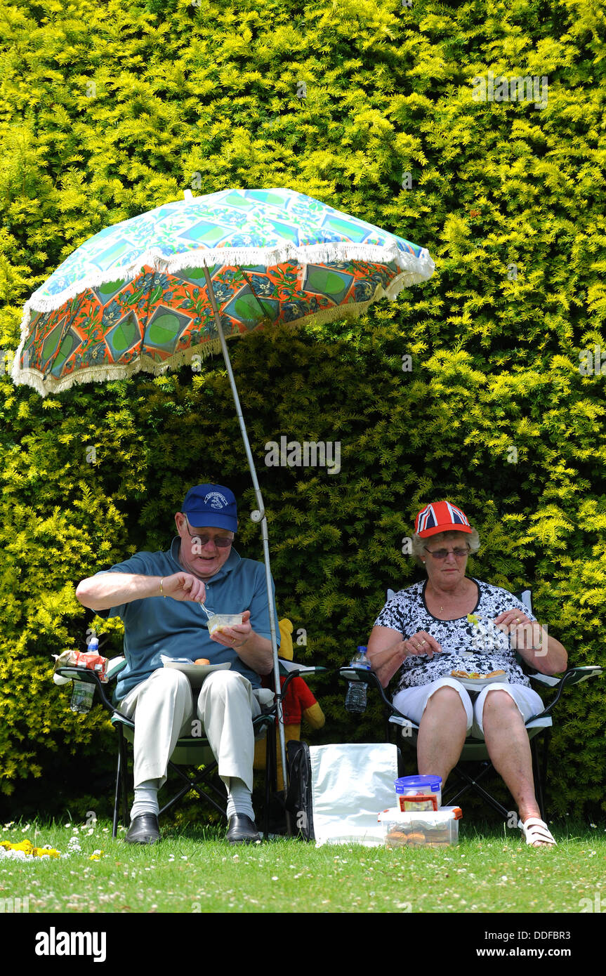 Couple pique-nique dans un parc britannique, deux personnes à l'extérieur profiter d'un pique-nique, England, UK Banque D'Images