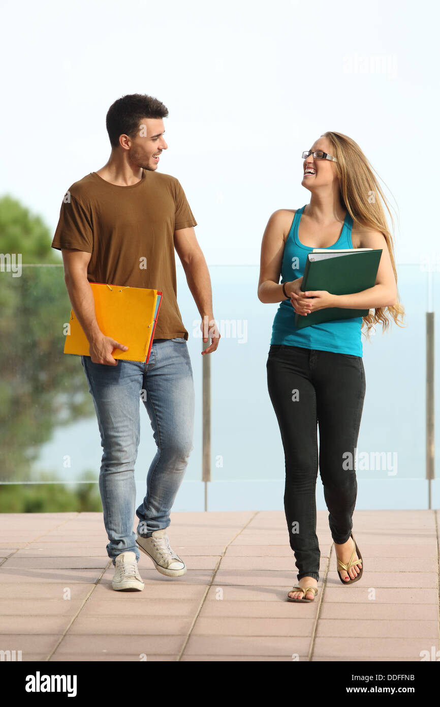 Les étudiants adolescent boy and girl walking towards camera and smiling Banque D'Images