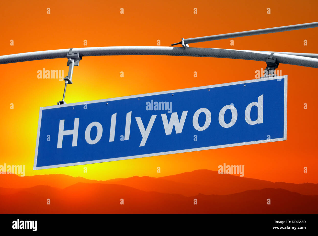 Hollywood Boulevard street sign et les montagnes avec ciel coucher de soleil orange. Banque D'Images