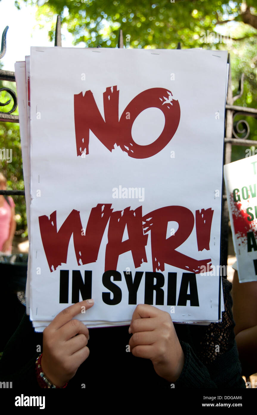 Manifestation contre toute intervention en Syrie.Une femme dissimule son visage derrière une pancarte disant "pas de guerre en Syrie". Banque D'Images