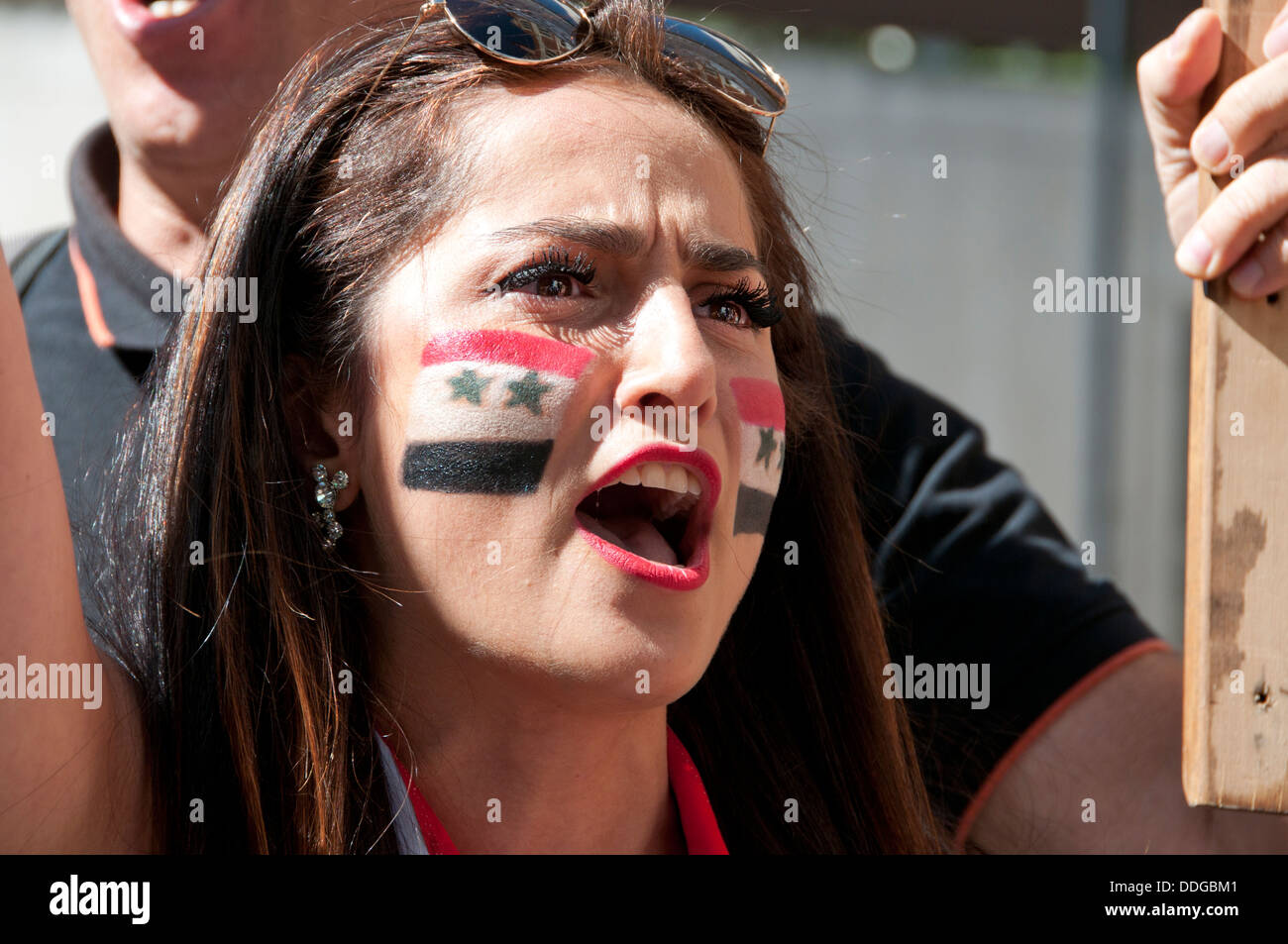 Jeune femme syrienne avec drapeau peint sur sa joue à la manifestation contre l'intervention en Syrie Banque D'Images
