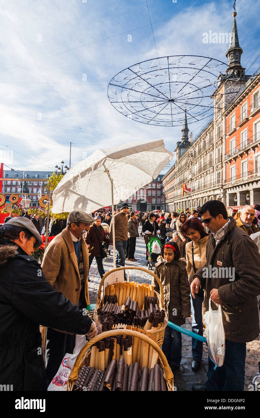 Famille qui achète des bonbons traditionnels barquillos gaufre au marché de Noël sur la Plaza Mayor, Madrid, Espagne Banque D'Images