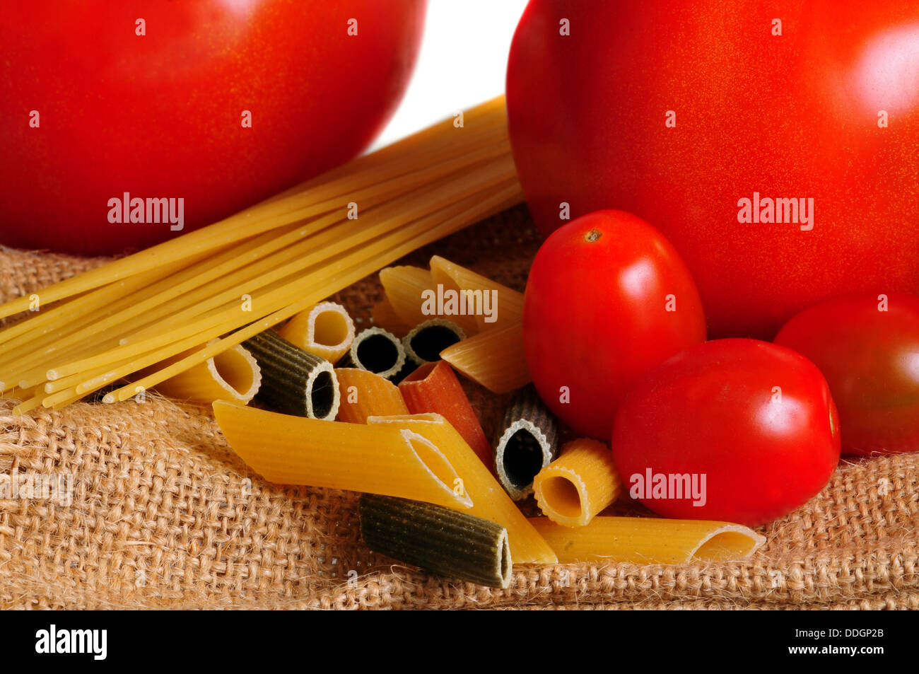 Plan macro sur les pâtes et les tomates sur un sac en tissu marron Banque D'Images