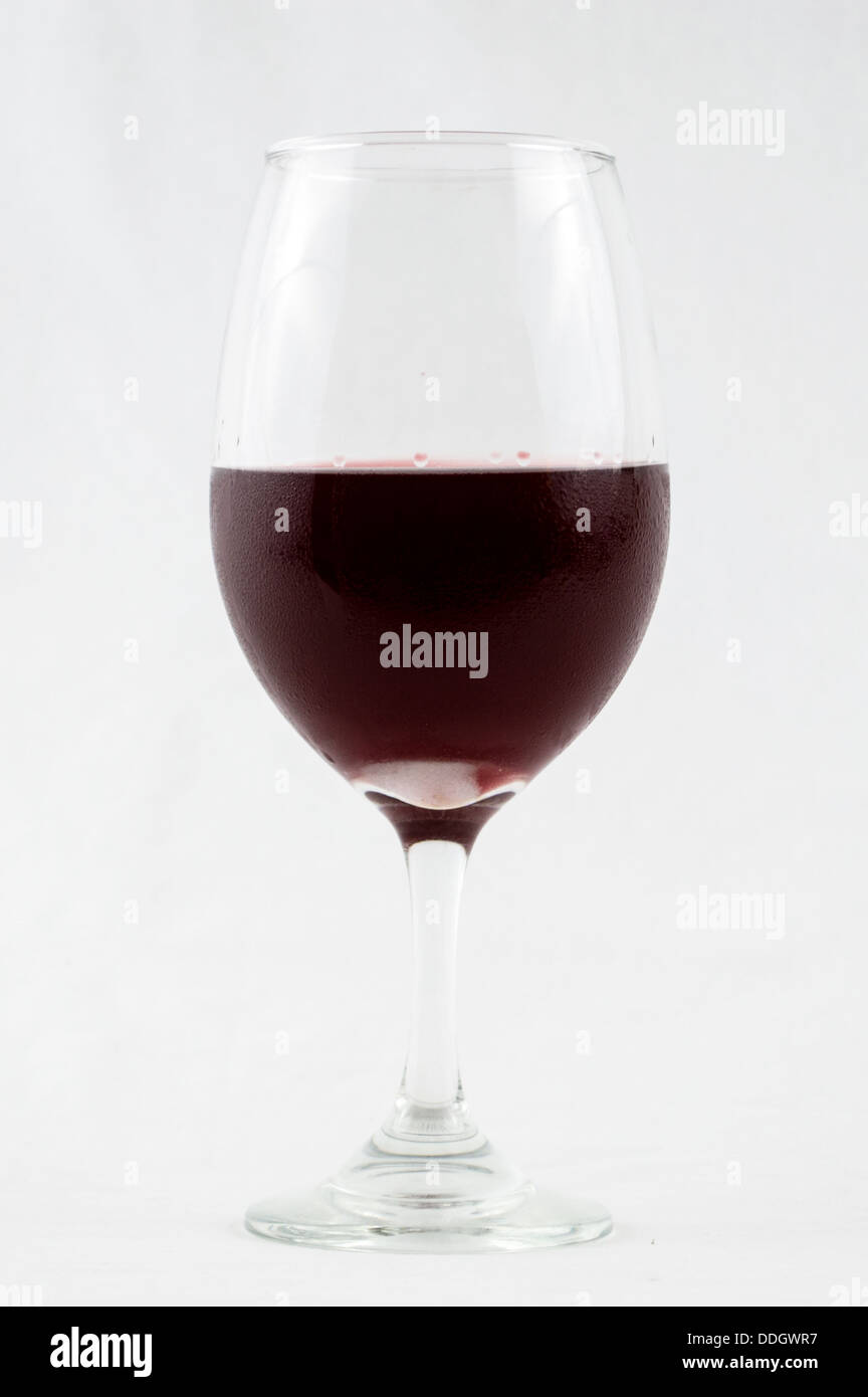 Verre de vin rouge, vin rose à moitié plein dans un verre de vin avec une tige isolé sur fond blanc avec la condensation sur le verre de vin. Banque D'Images