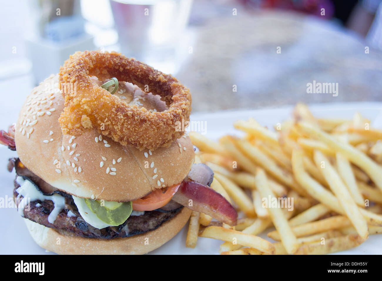 Hamburger avec Bacon Anneau Oignon Cornichons Tomate Patty de boeuf sauce Ranch et frites Banque D'Images