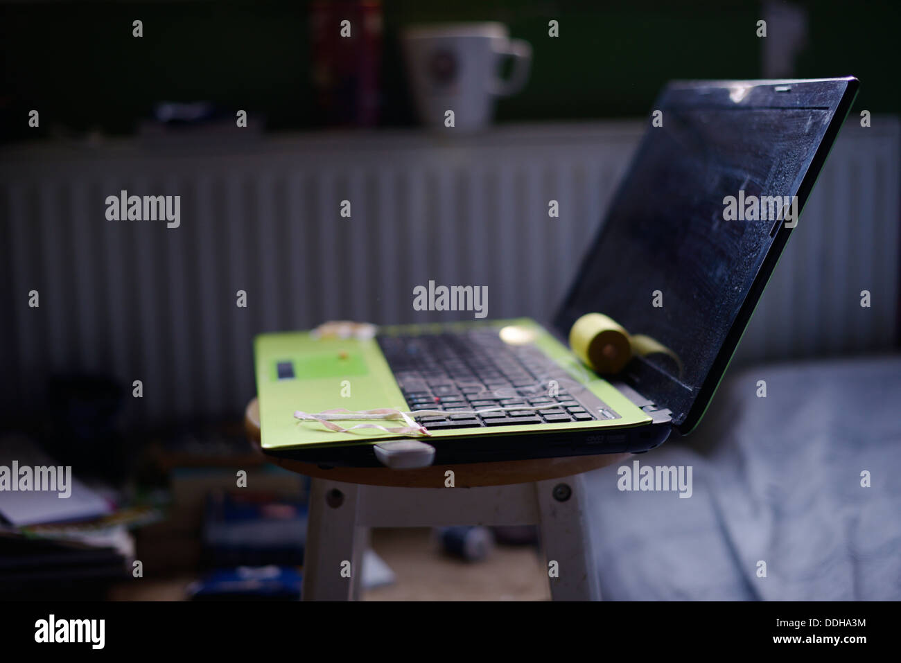 Ordinateur portable vert en équilibre sur un tabouret, Pays de Galles, Royaume-Uni Banque D'Images