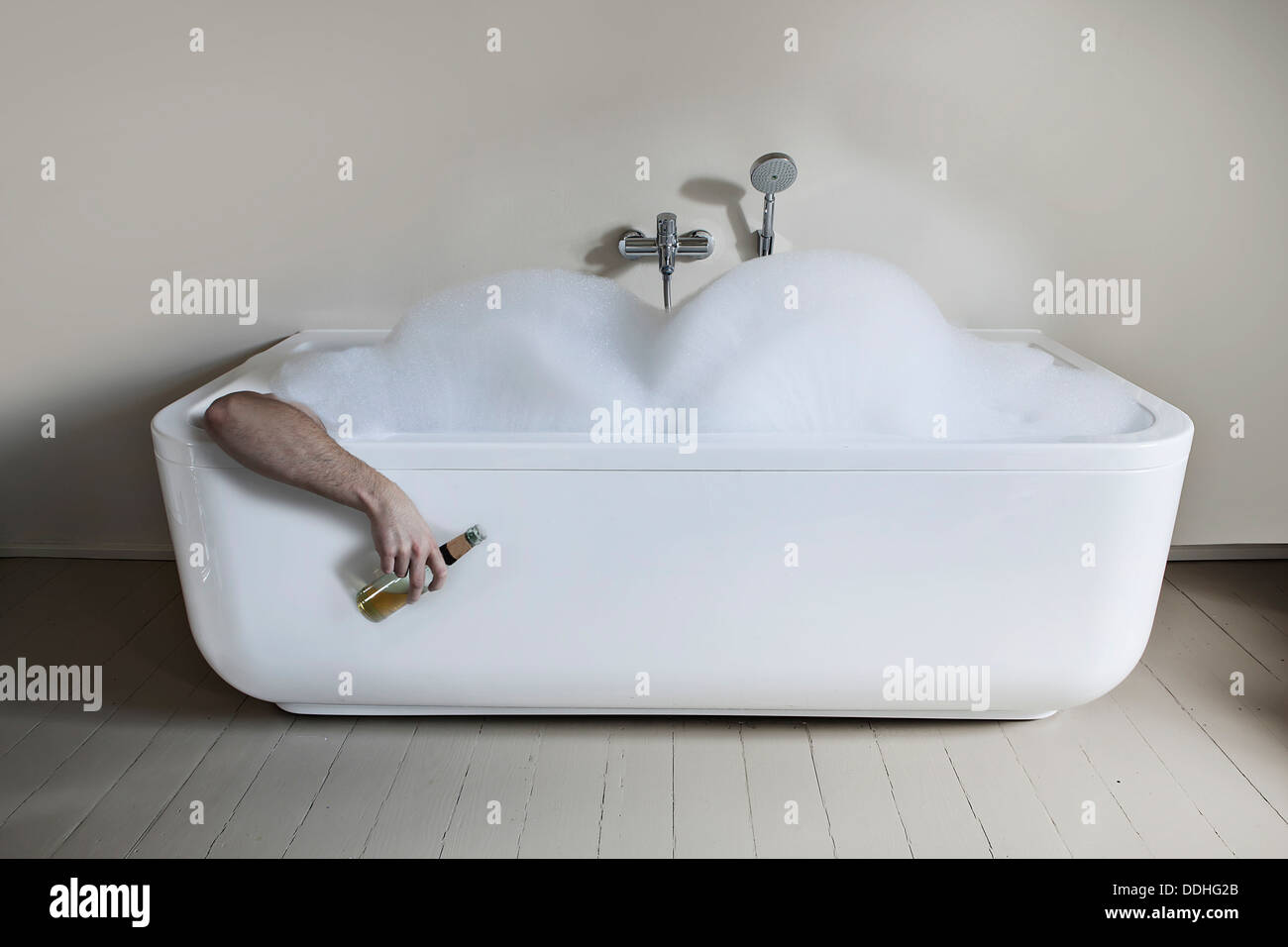 Mid adult man en baignoire avec bouteille de bière Photo Stock - Alamy