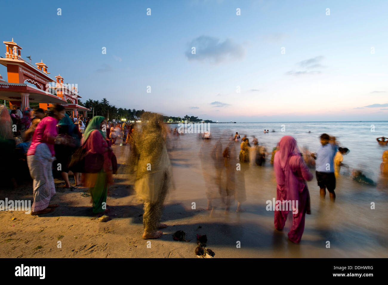 Pèlerins hindous en prenant un bain dans la mer sainte avant le lever du soleil, à l'Agni Theertham Ghat Banque D'Images