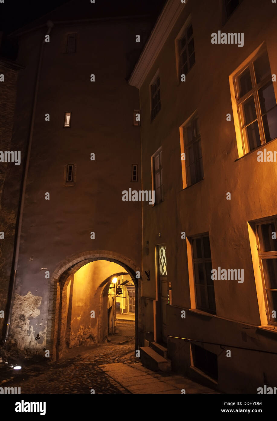 Rue sombre éclairée la nuit avec passerelle dans la vieille ville de Tallinn, Estonie Banque D'Images