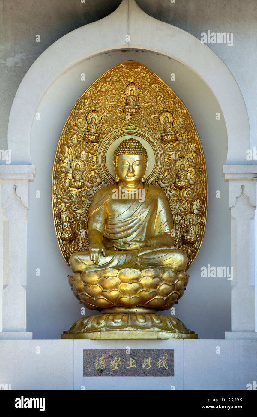 Une sculpture en bronze doré du Bouddha à la Pagode de la paix, Battersea Park, Londres. Banque D'Images
