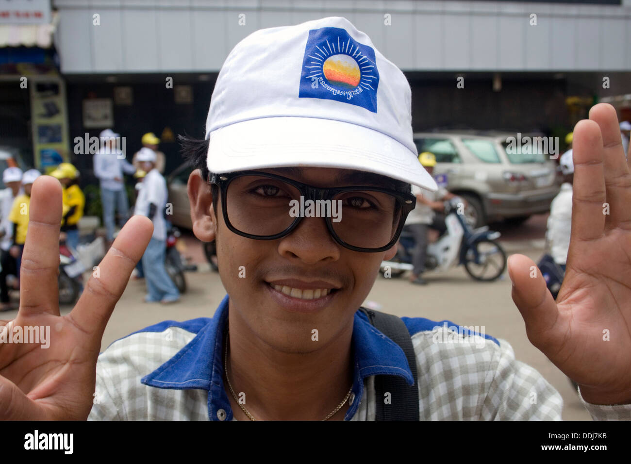 Un jeune homme portant des lunettes similaires à chef de l'opposition Sam Rainsy assiste à un rassemblement électoral à Kompong Cham au Cambodge. Banque D'Images