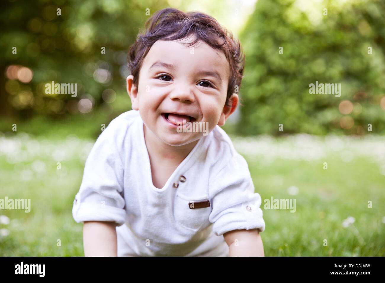 Baby Boy de ramper sur l'herbe, smiling Banque D'Images