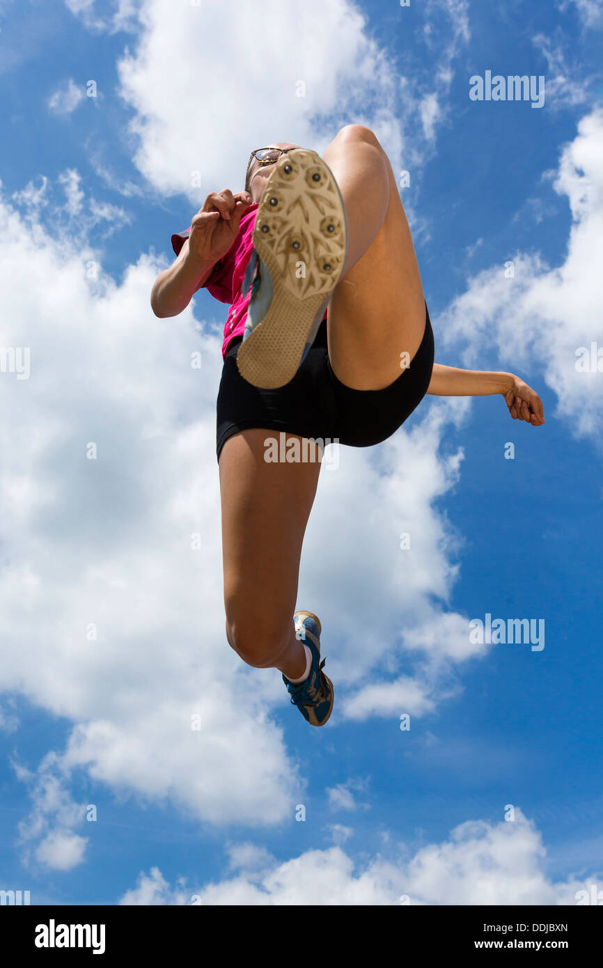 Allemagne, young woman doing long saut en athlétisme Banque D'Images