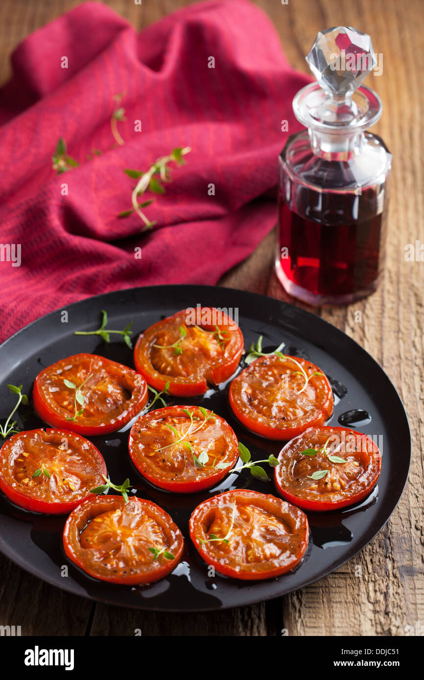 Les tomates cuites au four avec des herbes et d'huile d'olive Banque D'Images