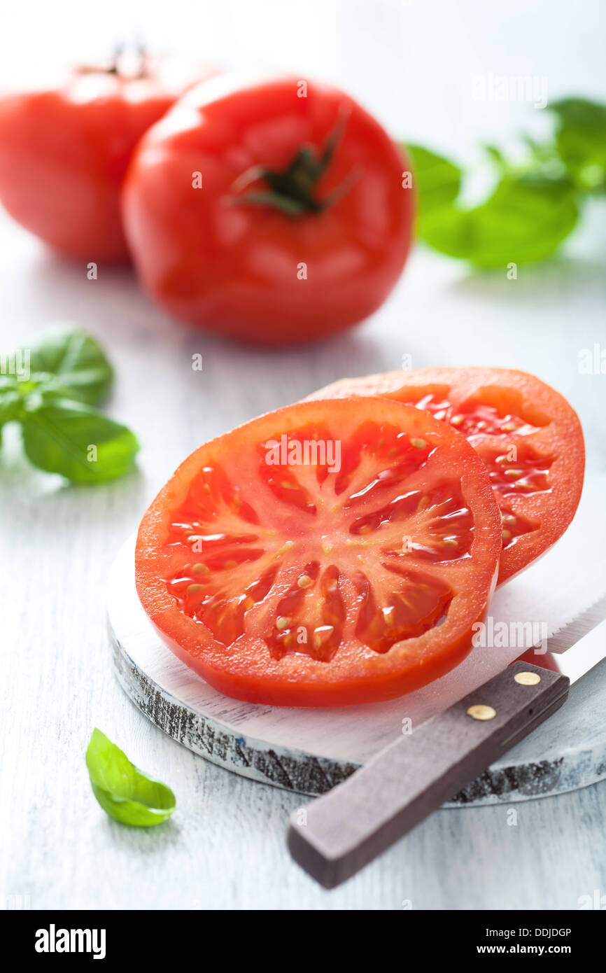 Tomates en tranches sur une planche à découper Banque D'Images