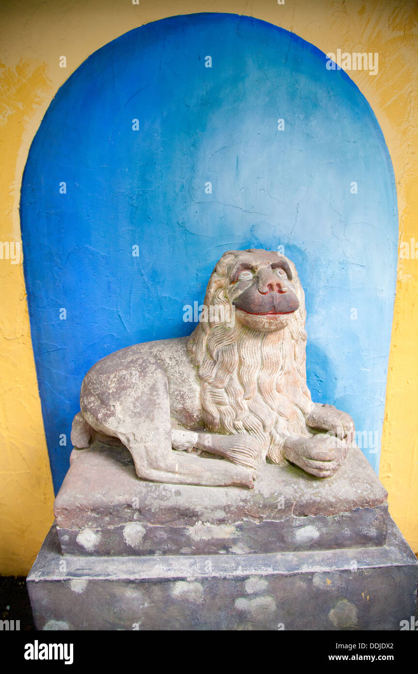 La sculpture sur pierre de style chinois / statue d'un lion à l'entrée de Portmeirion Village Banque D'Images