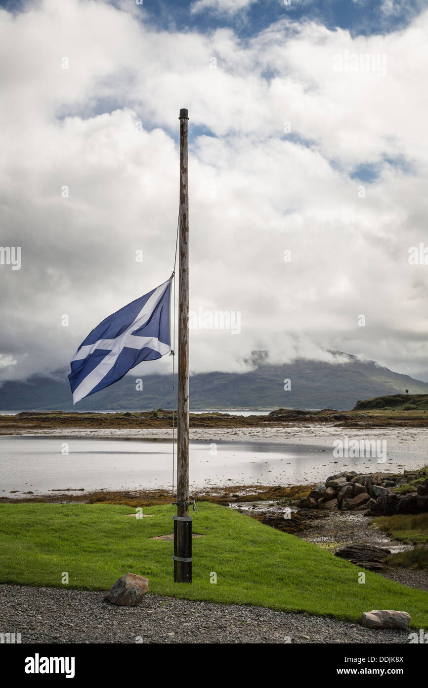 Drapeau national écossais se bloque la moitié de mât à l'Eilean Iarmain, île de Skye, Écosse Banque D'Images