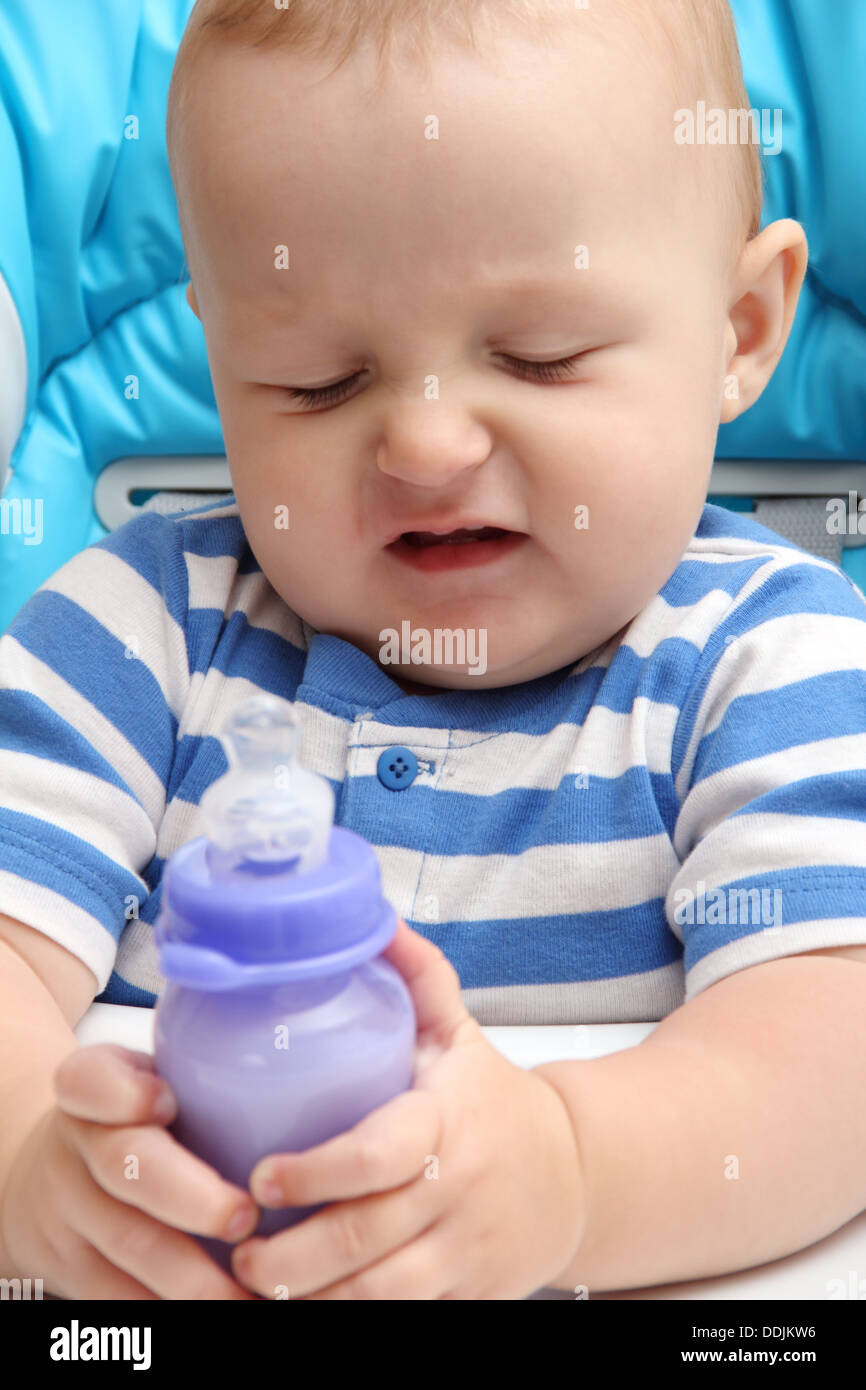 Bébé avec bouteille de lait mécontents Banque D'Images