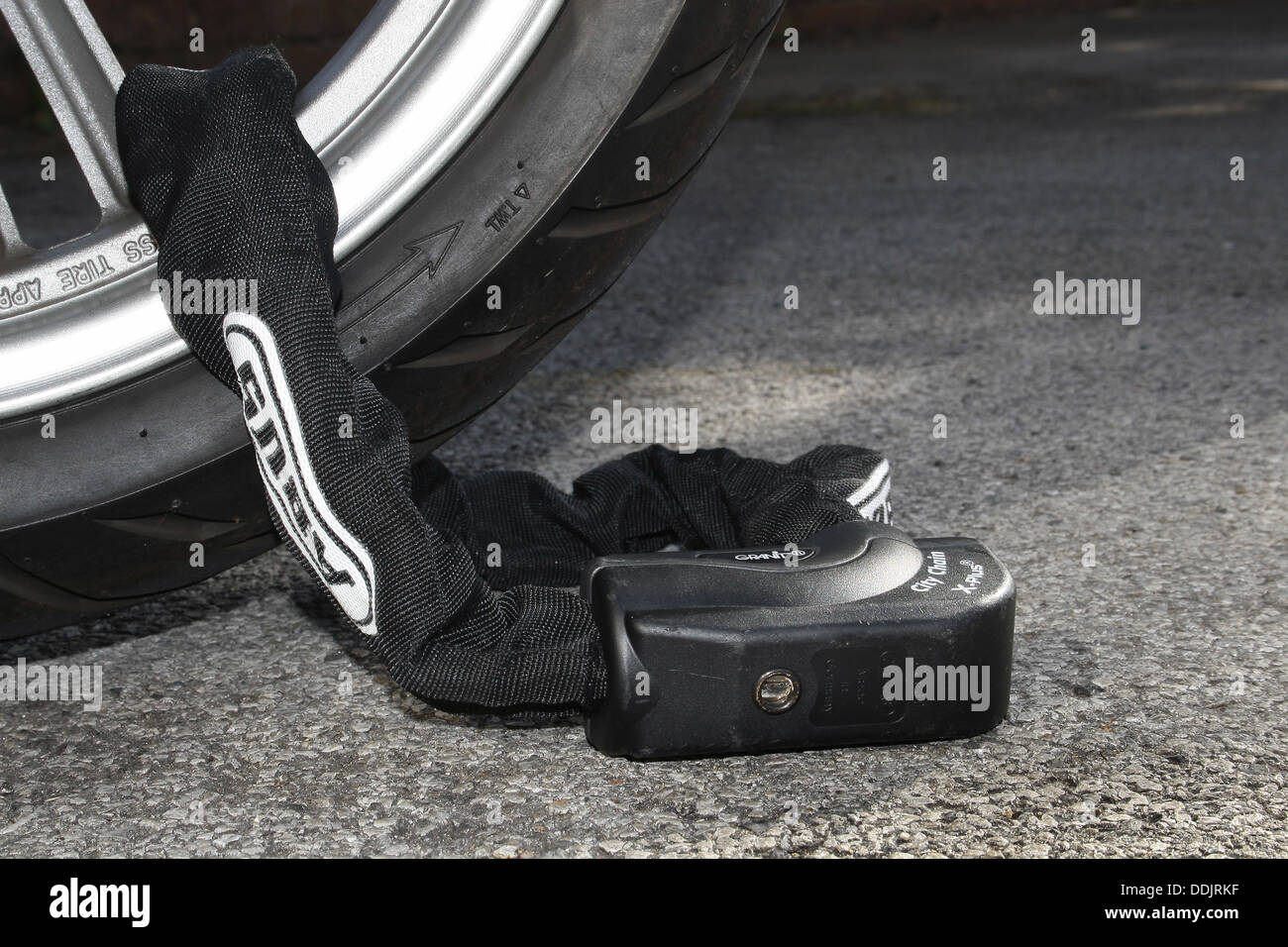 Abus chaîne et verrou de sécurité autour de la roue de scooter Banque D'Images