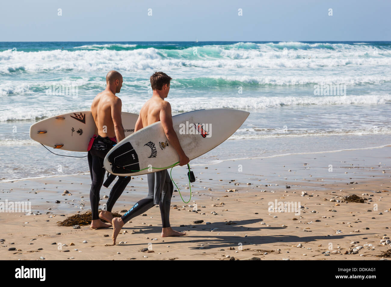 L'Angleterre, Cornwall, Newquay, plage de Fistral, Surfers Walking on Beach Banque D'Images