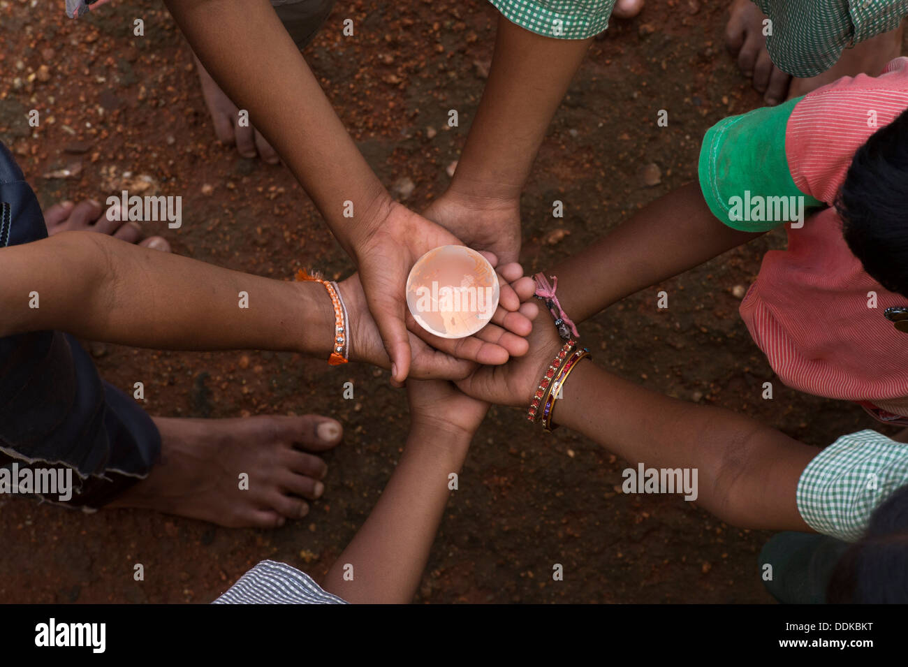 Les mains de childrens village situé dans un cercle tenant un globe en verre cristal / masse / monde. L'Andhra Pradesh, Inde Banque D'Images