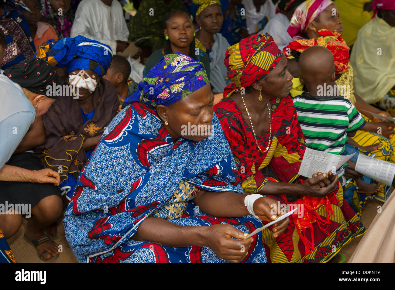 Femme assise sur un tas de lire un flyer au Nigeria Banque D'Images