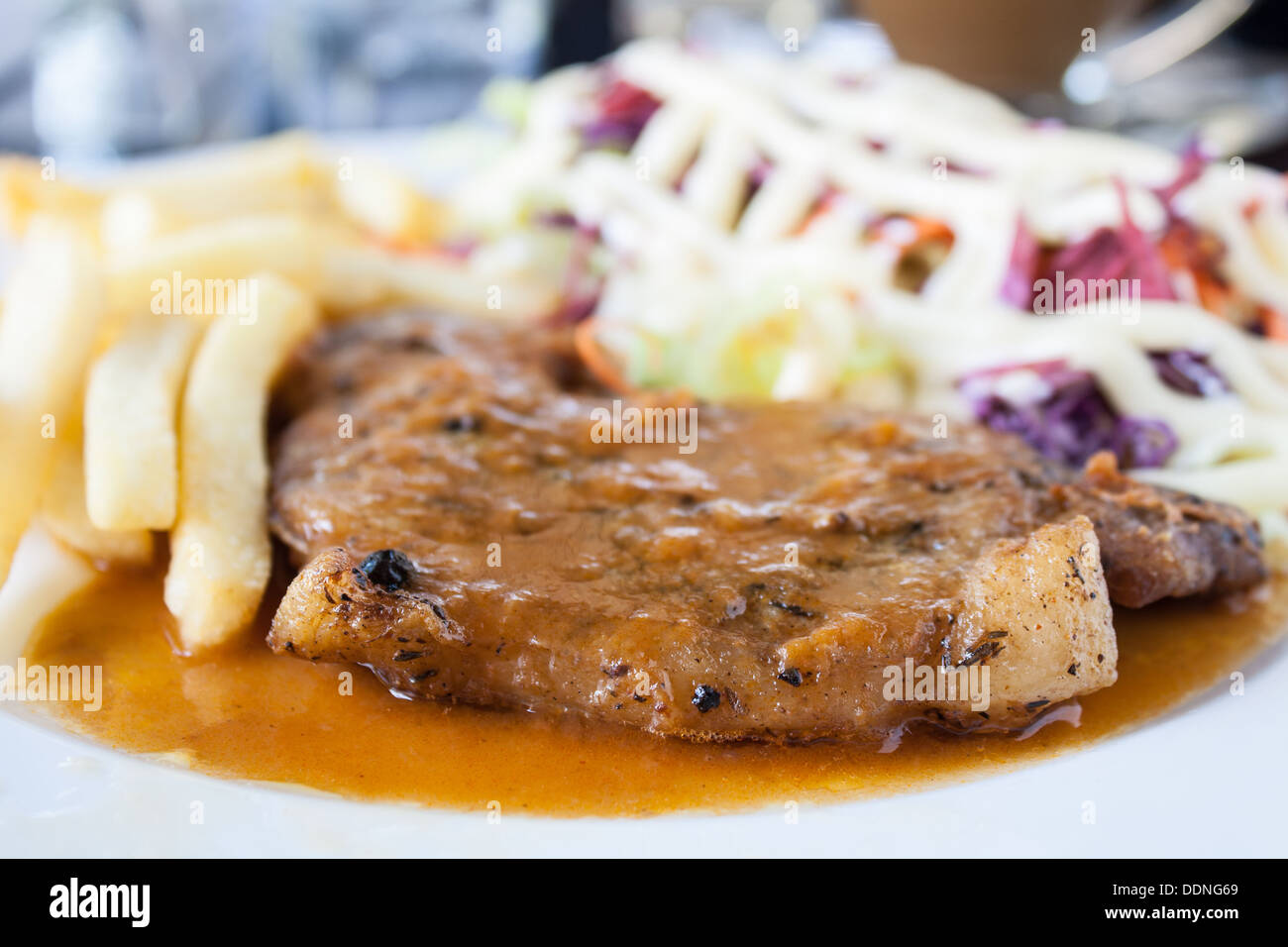 Escalope de porc avec frites et salade sur une assiette blanche. Banque D'Images