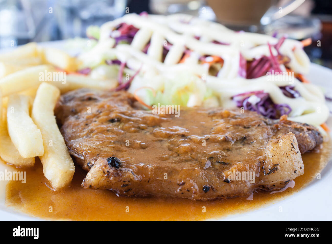 Escalope de porc avec frites et salade sur une assiette blanche. Banque D'Images