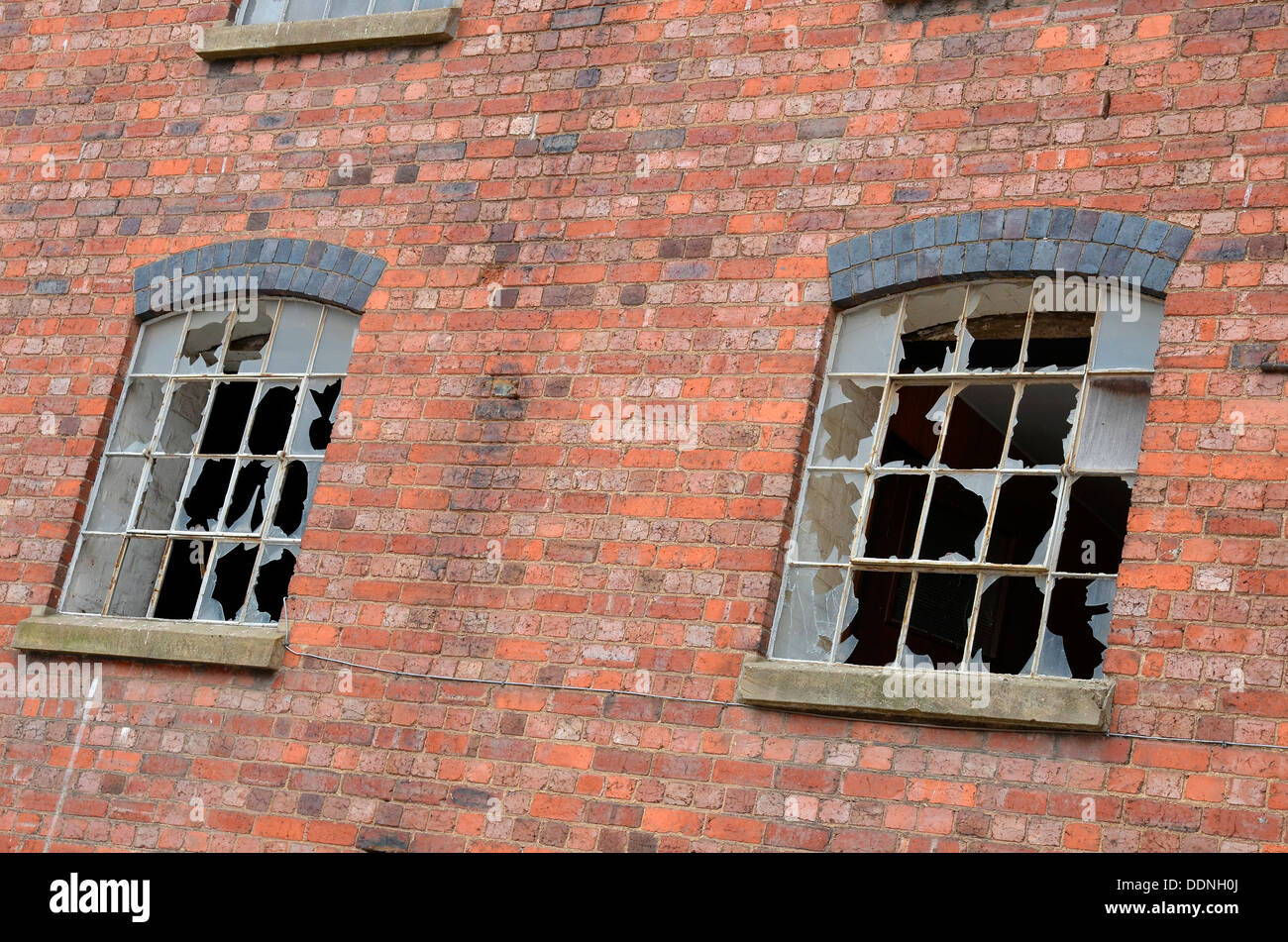 Fenêtres brisées dans une ancienne usine de style victorien dans une zone de réaménagement sur le bord du centre-ville de Worcester, en Angleterre. Banque D'Images