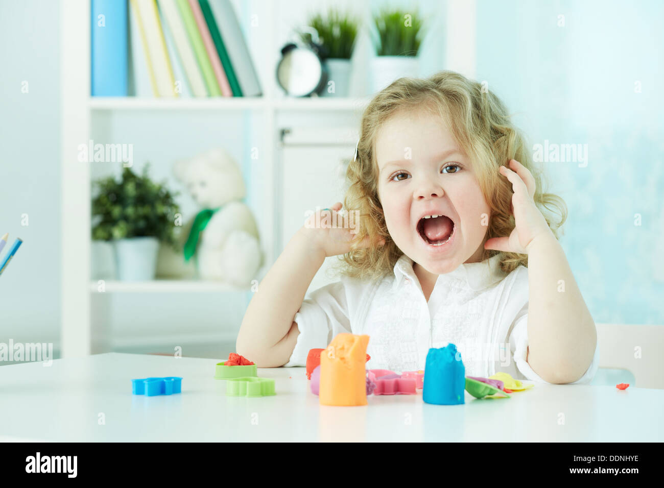 Heureux l'enfant bénéficiant de la modélisation elle-même, alors qu'avec l'argile colorée Banque D'Images