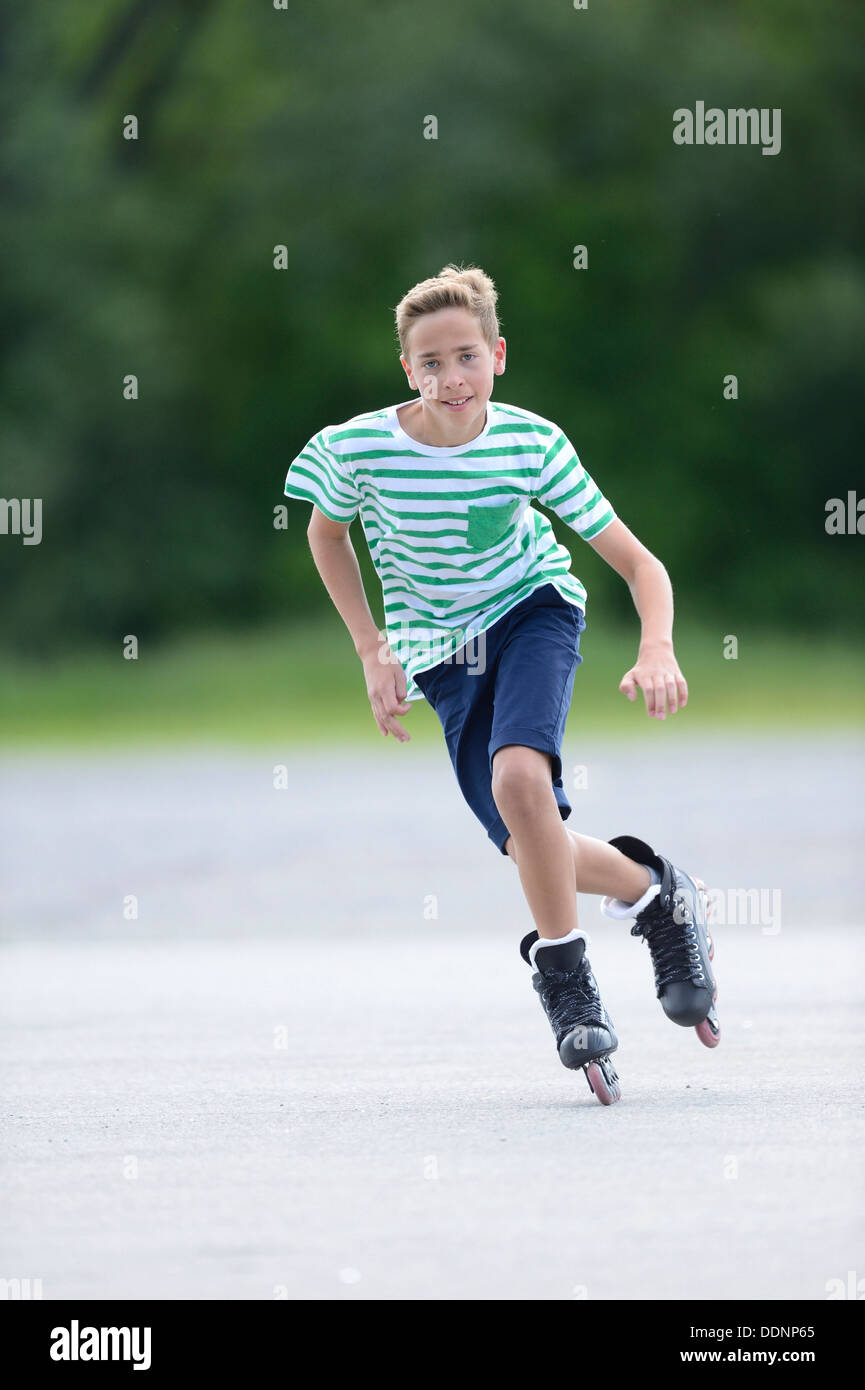 Garçon avec des patins à roues alignées sur une place de sport Banque D'Images