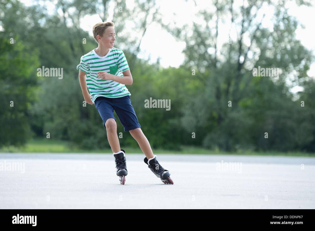 Garçon avec des patins à roues alignées sur une place de sport Banque D'Images