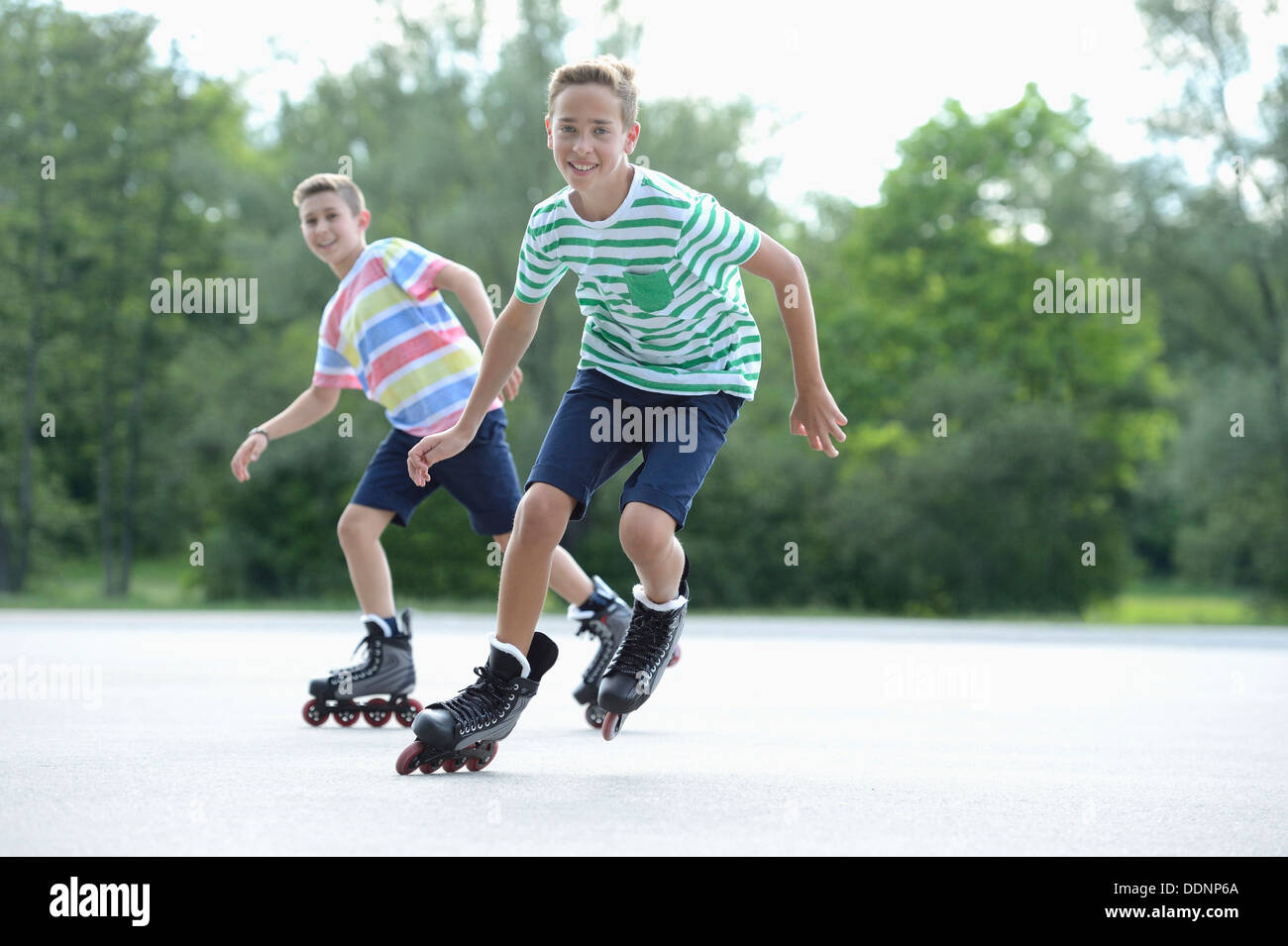 Deux garçons avec des patins à roues alignées sur une place de sport Banque D'Images