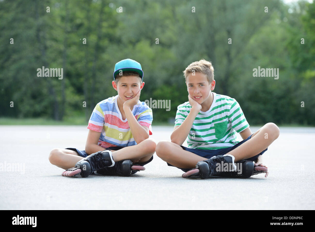 Deux garçons avec des patins à roues alignées sur une place de sport Banque D'Images